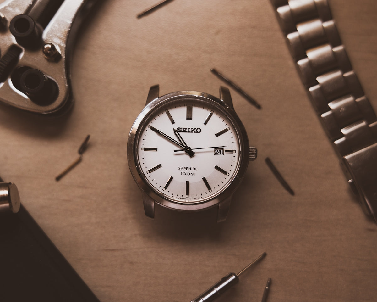 silver and white analog watch at 10 10