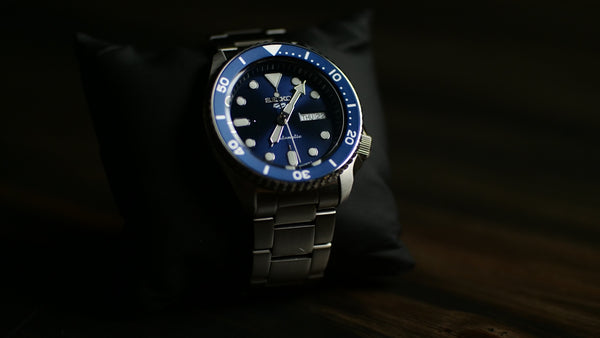 a blue and black watch sitting on a table